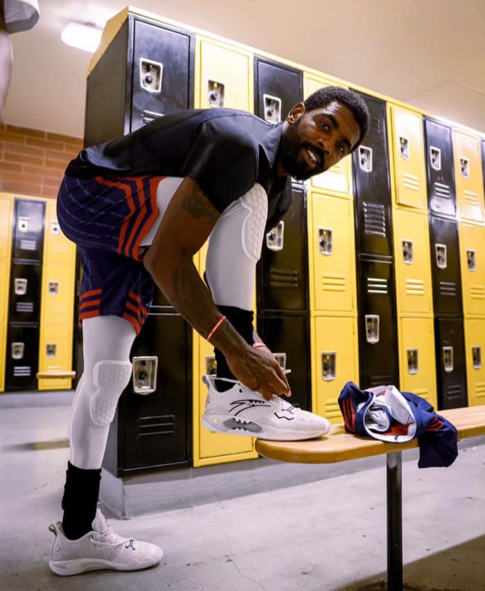 Kyrie Irving ties his sneakers before a Drew League basketball game.